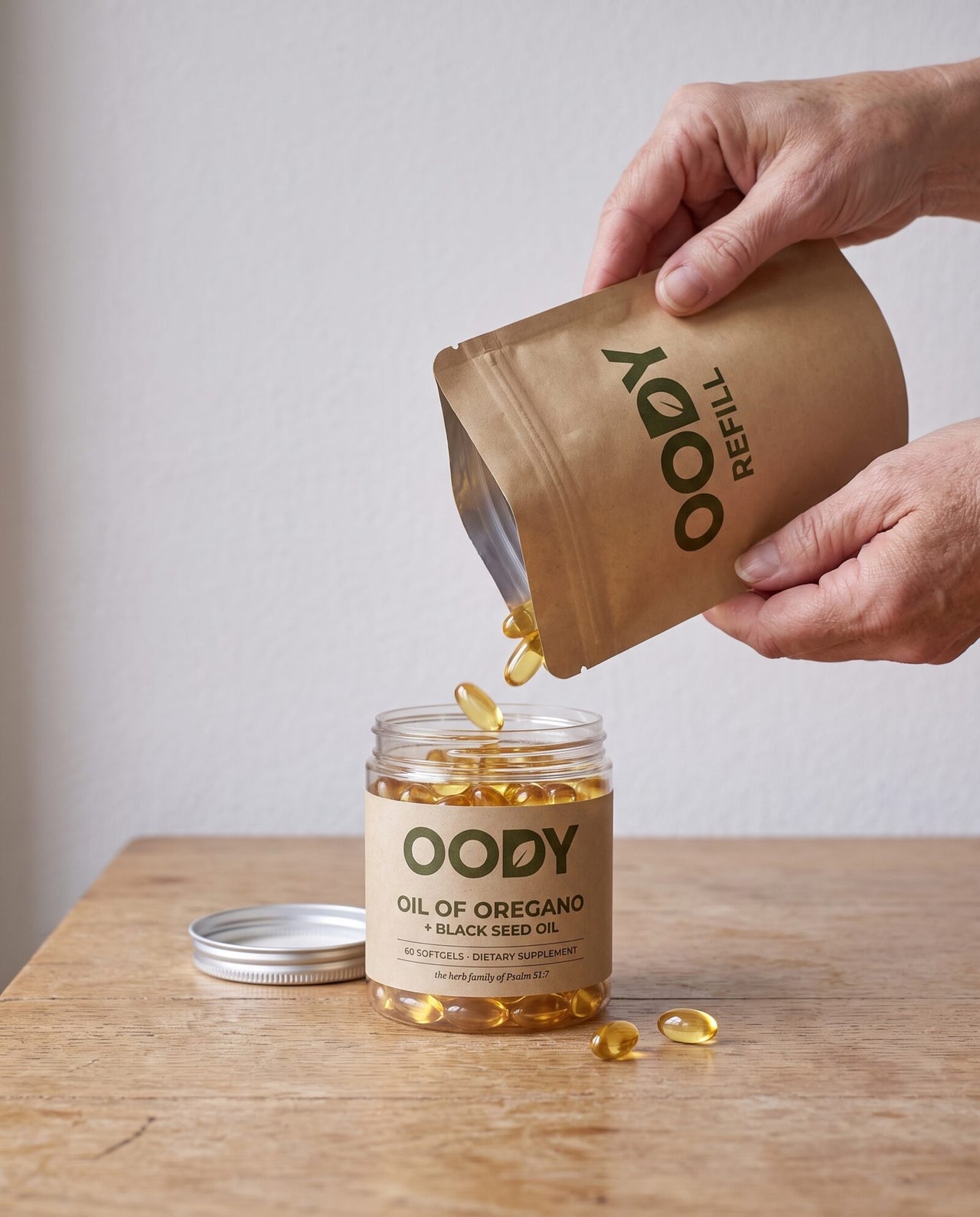 Softgels being poured from an OODY kraft refill pouch into the jar